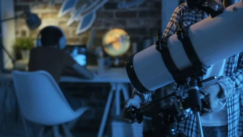 Cute boy looking at the stars through a telescope at night Stock Footage 128499593