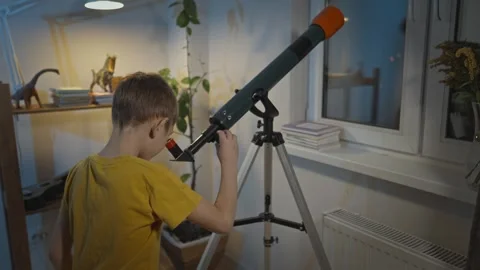 Cute boy is looking through a telescope at the night starry sky Stock Footage 286307493