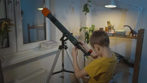Cute boy is looking through a telescope at the night starry sky Stock Footage 286307612