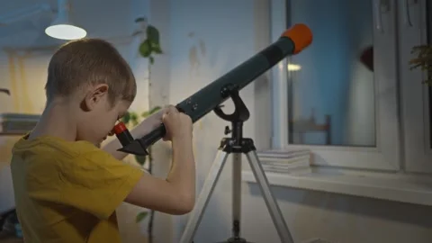 Cute boy is looking through a telescope at the night starry sky Stock Footage 286307695
