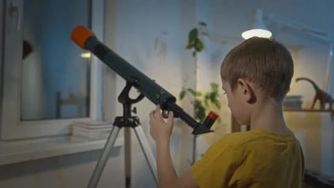 Cute boy is looking through a telescope at the night starry sky Stock Footage 286307882