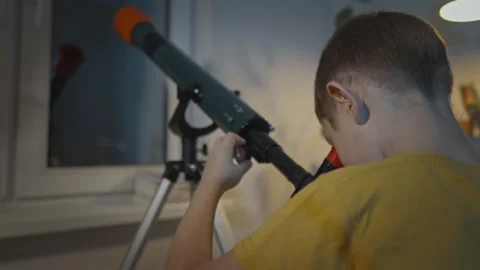 Cute boy is looking through a telescope at the night starry sky Stock Footage 286308065