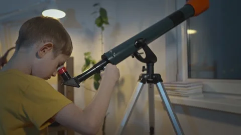 Cute boy is looking through a telescope at the night starry sky Stock Footage 286308130