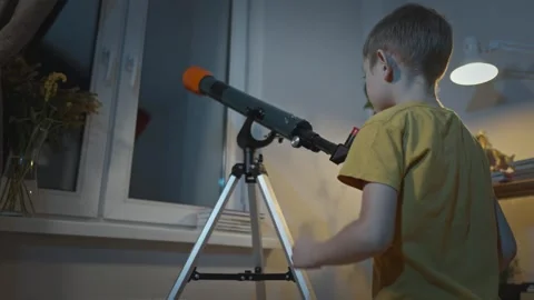 Cute boy is looking through a telescope at the night starry sky Stock Footage 286308262