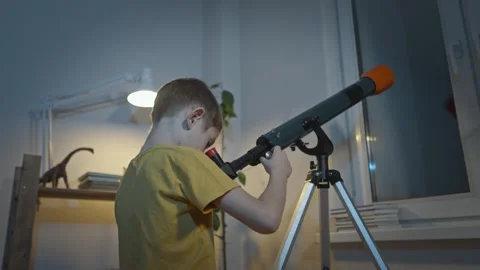 Cute boy is looking through a telescope at the night starry sky Stock Footage 286308330