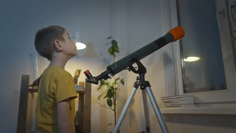 Cute boy is looking through a telescope at the night starry sky Stock Footage 286308608
