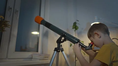 Cute boy is looking through a telescope at the night starry sky Stock Footage 286308730