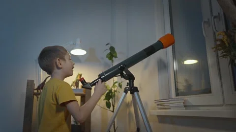 Cute boy is looking through a telescope at the night starry sky Stock Footage 286308820