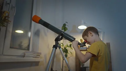 Cute boy is looking through a telescope at the night starry sky Stock Footage 286308837