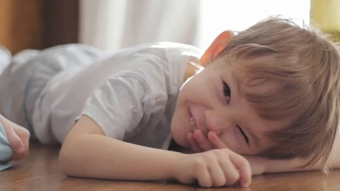 Cute boy lying on the floor looking at camera, portrait Stock-Footage 85595028
