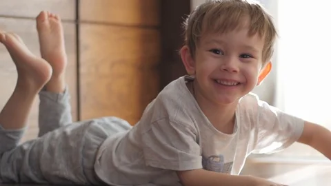 Cute boy lying on floor looking at camera, portrait Video stock 85595171