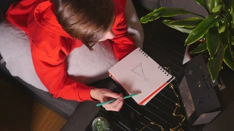 Cute boy lying on sofa and drawing sketch Stock Footage 144180456