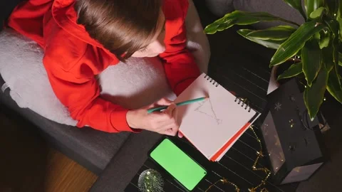 Cute boy lying on sofa drawing sketch, green screen phone near Stock Footage 144315698