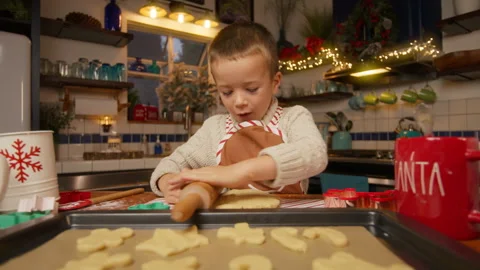 Cute boy making gingerbread cookies using rolling pin Christmas tree patterns 4K Stock Footage 257887956