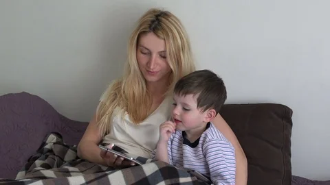 Cute boy with mom watching video on mobile phone Stock Footage 75264033