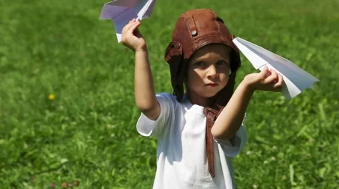 Cute boy in the old helmet pilot playing with paper plane Stock Footage 56538755