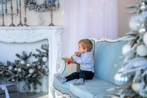 A cute boy opens a gift box in a New Year's atmosphere Foto stock