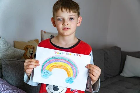 A cute boy with a painted rainbow with EVERYTHING WILL BE GOOD in French, asks Foto stock