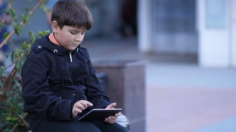 Cute boy in the park playing on the tablet Stock Footage 96165318