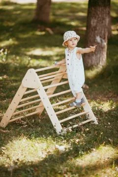 Cute boy performs gymnastic exercises on a wooden home sports complex stairs. Stock Photos