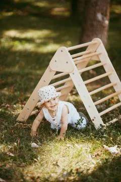 Cute boy performs gymnastic exercises on a wooden home sports complex stairs. Foto stock