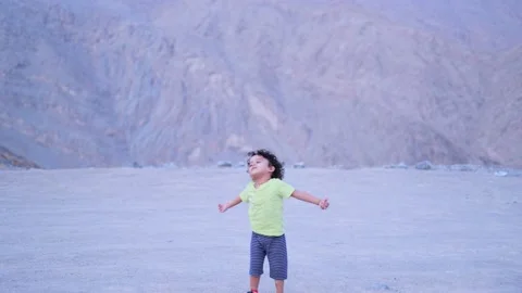 Cute boy playing alone and express his happiness at the top of a mountain he Stock Footage 159661459