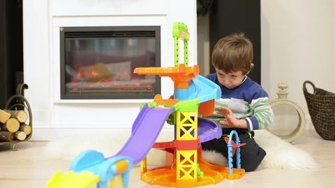 Cute boy playing alone with a modular parking toy Video stock 95600385