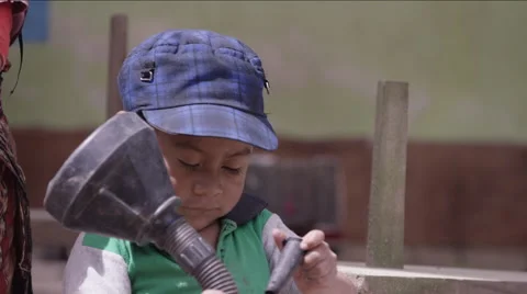 Cute boy playing with a black funnel, Guatemala Stock Footage 63054426