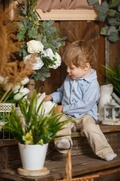 Cute boy playing with Easter white bunny Fotos de archivo