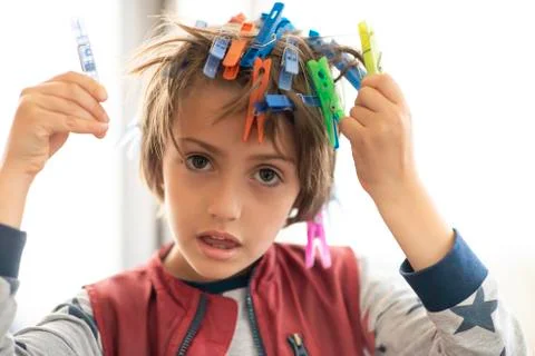 Cute Boy Playing with Laundry Hooks Stock Photos
