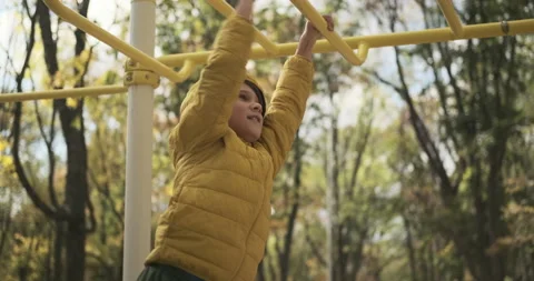 Cute boy playing on monkey bars Stock Footage 142714497