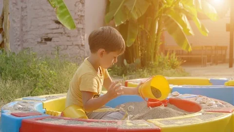Cute boy playing with sand in a sandbox Stock Footage