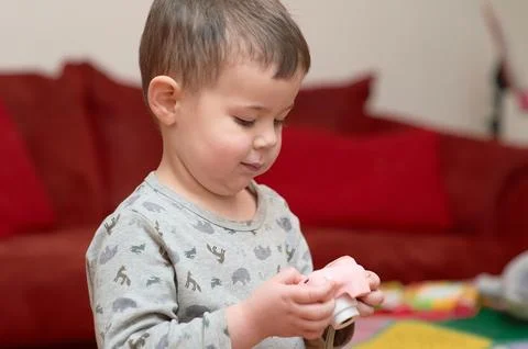 Cute boy playing with a toy camera while watching tv at home by the couch Stock Photos
