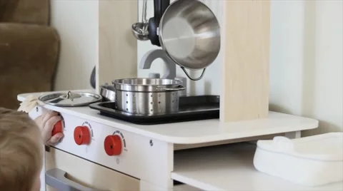 A cute boy playing with a toy kitchen Stock Footage 46870165