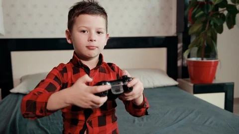 Cute boy playing video game, holding joystick, having an emotional time Stock-Footage 125739245