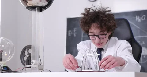 Cute boy plays with a Newton's Cradle. A young boy dragging a small metal ball Stock-Footage 172199538