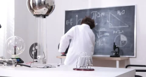Cute boy plays with a Newton's Cradle. A young boy dragging a small metal ball Stock Footage 172199614