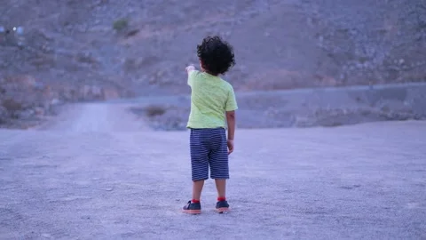 Cute boy pointing his hand and showing something in the mountain wearing in y Stock Footage 159662202