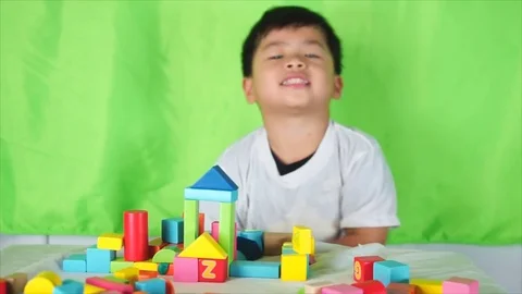 Cute boy put the colored bricks together, Stock-Footage 75820384