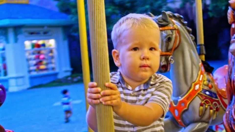 Cute boy riding on the carousel Stock Footage 101449672