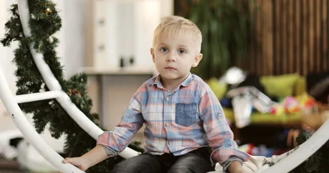 Cute boy is riding on a Christmas swing in the studio. Stock Footage 140157413