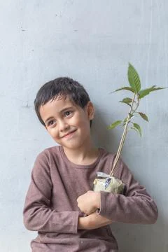 A cute boy sat hugging a tree on his chest. Stock Photos