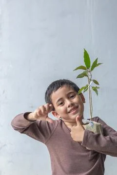 A cute boy sat hugging a tree on his chest. Stock Photos