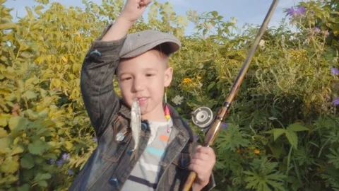 Cute boy is showing caught fish Stock Footage 78634704