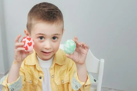 Cute boy showing painted Easter eggs. Blond kid decorated Easter eggs at home Stock Photos