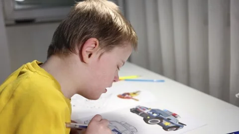 Cute boy sings a song while working on his drawing. Stock Footage 300502898