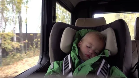 Cute boy is siting and slipping in the car chair Stock Footage 80497874