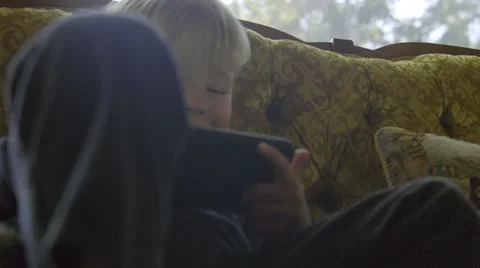 Cute boy sits and plays on a phone Video stock 64644903