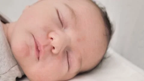 A cute boy sleeps on the bed during the day. Protection of children. Stock Footage 235392359