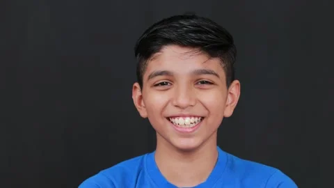 Cute boy smiling closeup view he is wearing blue dress in black background Stock Footage 160550165